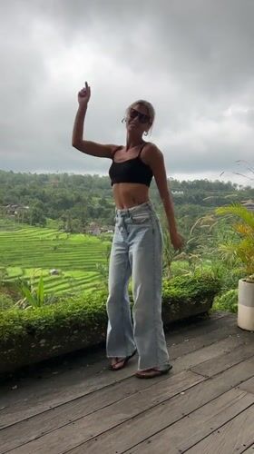 Women dance and pose on deck overlooking Penebel rice paddies
