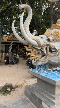 Kuta Beach scenes: ornate sea creature statue, beachside restaurant