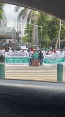 Midday street scenes in Abuja including a banner-holding gathering