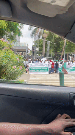 Midday street scenes in Abuja including a banner-holding gathering