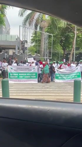 Midday street scenes in Abuja including a banner-holding gathering