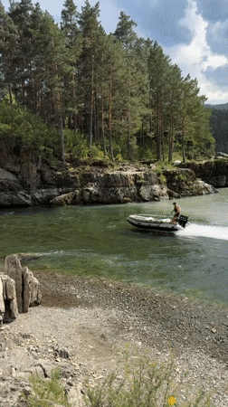 Boats navigating a green mountain river near Chemal, Russia