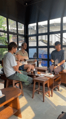 Three men gather for guitar session in Pokhara room