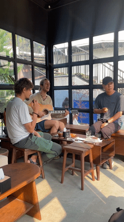 Three men gather for guitar session in Pokhara room