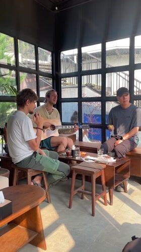 Three men gather for guitar session in Pokhara room