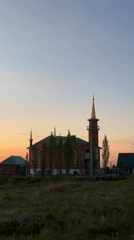 Red brick mosque photographed at sunset with crescent minaret