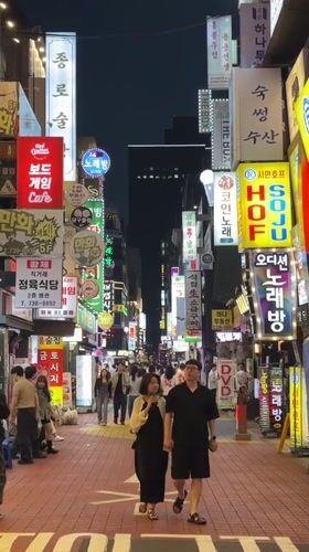 Couple walks hand-in-hand on busy Seoul street