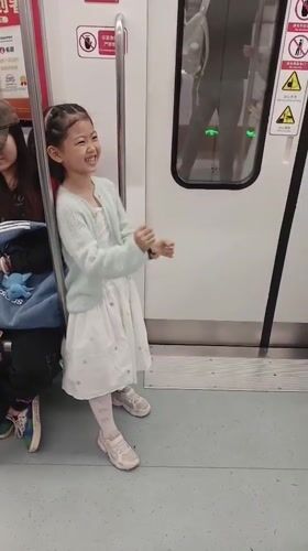 Young girl makes playful gestures on Yuzhong District subway