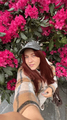 Woman photographs blooming rhododendrons during afternoon rain shower