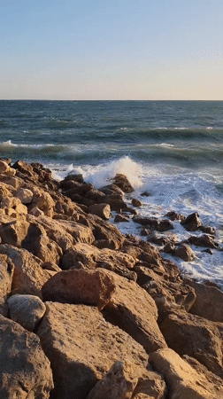 Golden hour on Quarteira's rocky beach shoreline