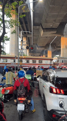 Train crosses Bangkok street as traffic waits below overpass