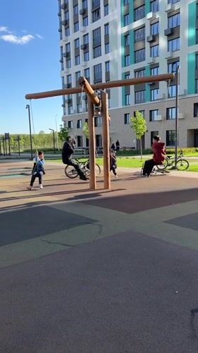 Children play at playground near bicycle mural in Ufa