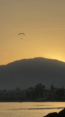 Paragliding over Estepona at sunset, mountains and coast below
