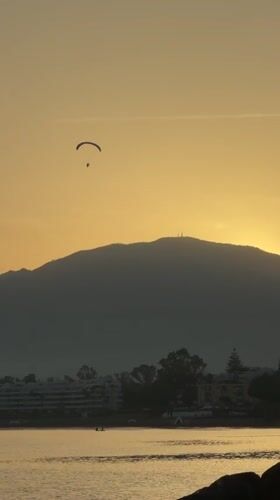 Paragliding over Estepona at sunset, mountains and coast below
