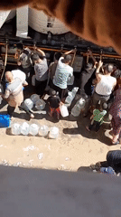 Water distribution from a tanker truck in Khan Yunis