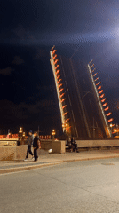 Saint Petersburg drawbridge raised at night, decorated with flags