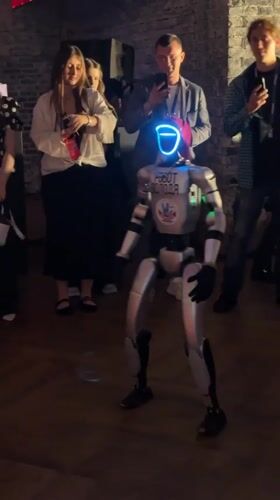 Dancing robot and evening crowd at Moscow event