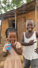 Children enjoy drinks outside homes in rural Nigeria