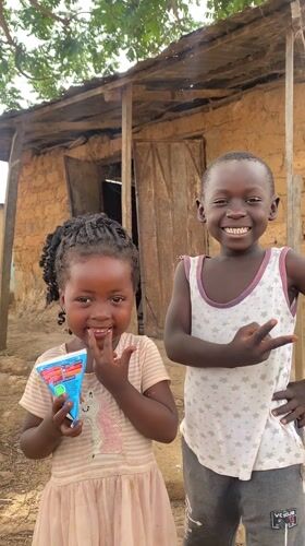 Children enjoy drinks outside homes in rural Nigeria