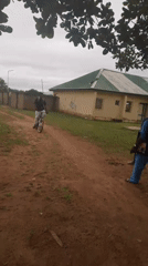 Cycling and conversation on a dirt road in rural Nigeria
