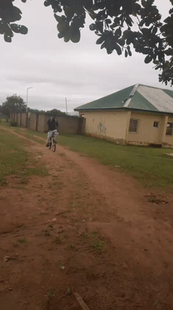 Cycling and conversation on a dirt road in rural Nigeria