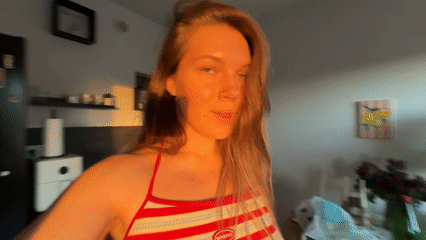 Woman dances in Belgrade kitchen, sparkling water nearby
