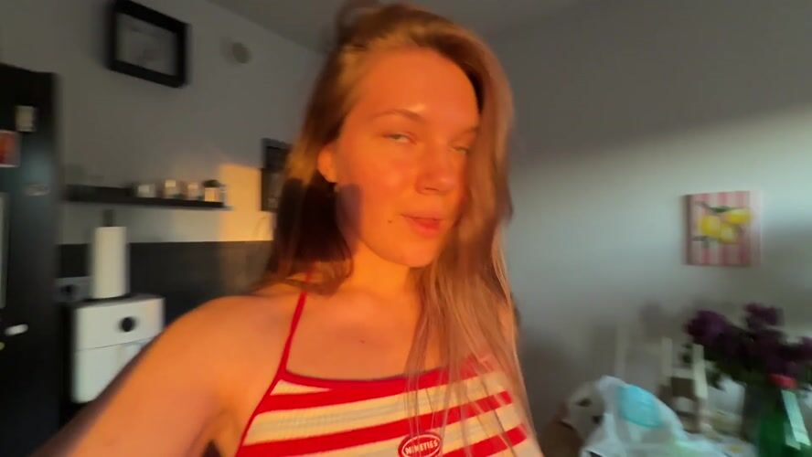 Woman dances in Belgrade kitchen, sparkling water nearby
