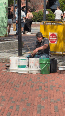 Street drummer performs on paint buckets in Boston