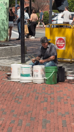 Street drummer performs on paint buckets in Boston