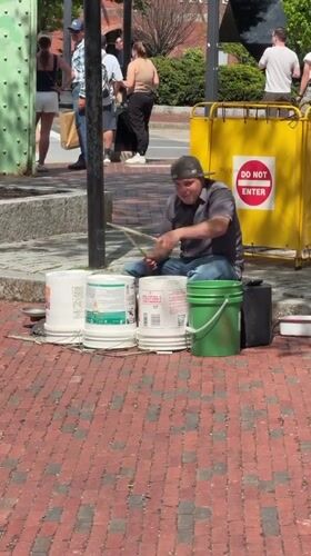 Street drummer performs on paint buckets in Boston