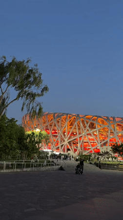 Evening visitors explore illuminated Beijing Olympic Park facilities