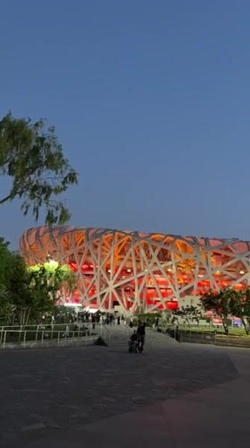 Evening visitors explore illuminated Beijing Olympic Park facilities