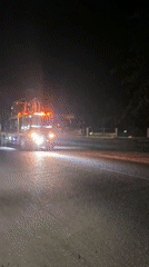 Construction truck travels night road in Lhokseumawe, Indonesia