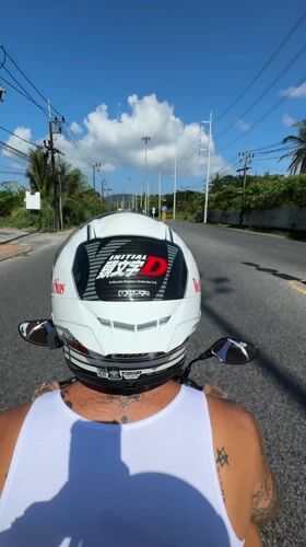 Motorcyclist with anime stickers rides sunny Kathu road