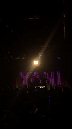 Crowded nightclub event under colorful stage lighting at YANI