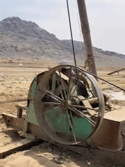 Drilling operation observed in rural Afghanistan, workers rest nearby