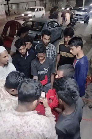 Teen group gathers in Dhaka alley near political posters