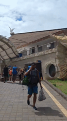 Traveler walks past traditional Balinese demon statue in Denpasar terminal