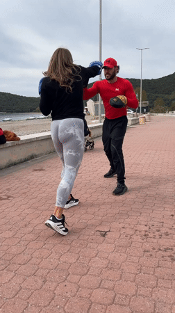 Woman practices boxing on seaside promenade in Montenegro