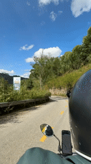 Motorcyclist navigates winding road with phone map in Vietnam