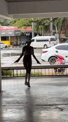 Woman exercises outdoors while pigeons gather in puddles, Thailand