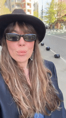Woman in fedora and blazer walks Tbilisi streets