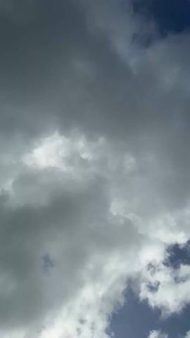 The video shows a sky filled with gray and white clouds, with small patches of blue sky visible in the corners. The clouds appear dense and layered, suggesting an overcast day. There are no people or objects visible in the video, and the focus is solely on the atmospheric conditions.