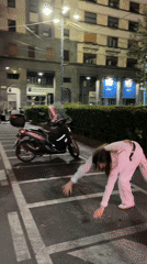 Woman performs nighttime cartwheel in Milan parking lot