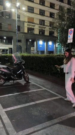 Woman performs nighttime cartwheel in Milan parking lot