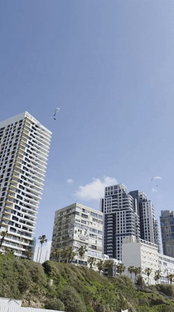 Pleasant beach day draws paragliders, walkers, sailors to Bat Yam