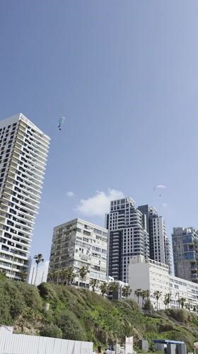 Pleasant beach day draws paragliders, walkers, sailors to Bat Yam