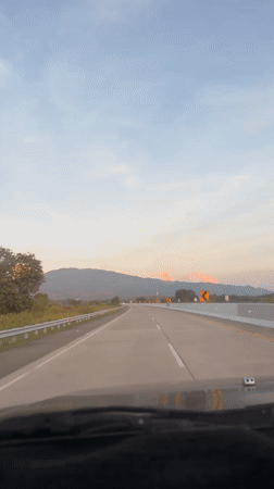 Evening highway travel captured near Indonesian mountains at sunset