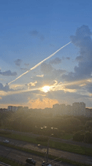 Golden sunset rays break through clouds over a Russian city