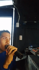 Man delivers speech with microphone in dark room
